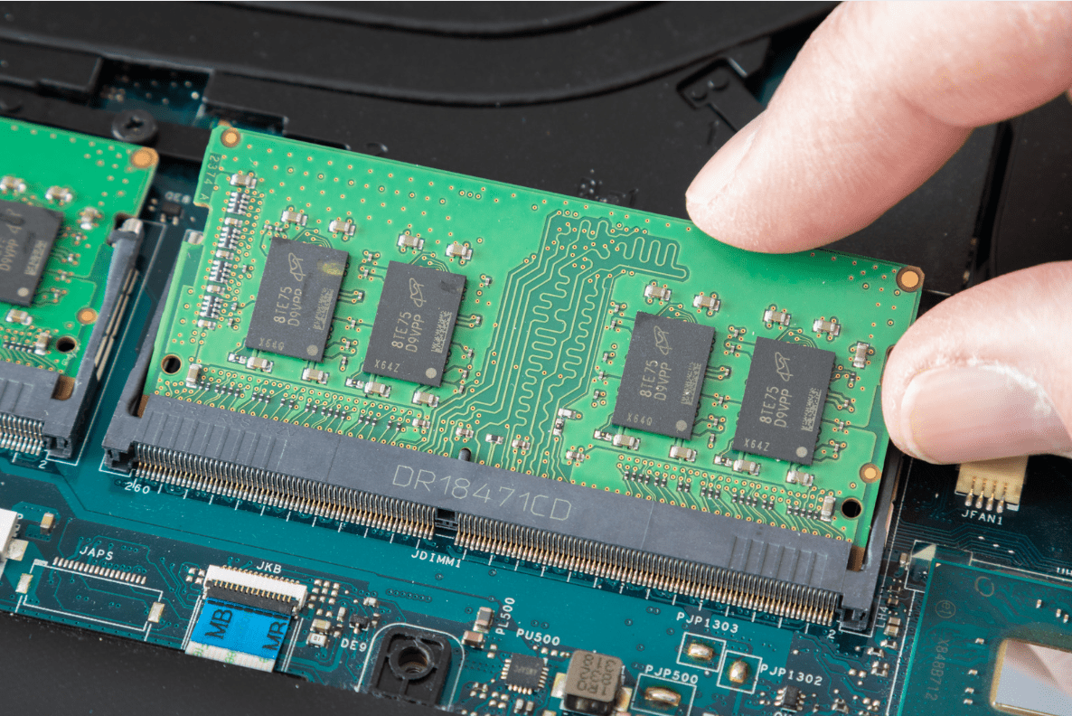 Hand installing a RAM module into a computer motherboard