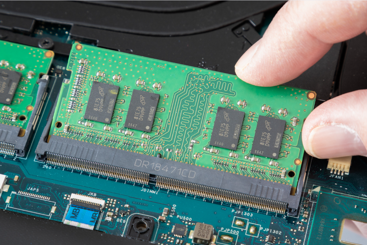 Hand installing a RAM module into a computer motherboard