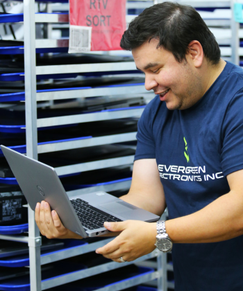 Evergreen electronics employee running diagnostics on a laptop.