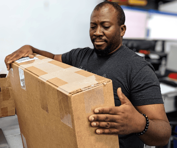 Evergreen Electronics Packer inspecting a package before shipment.
